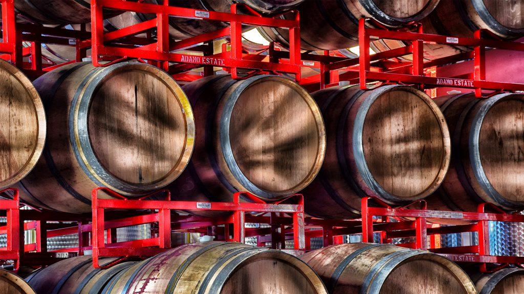 wine barrels on red racks at Adamo Estate Winery