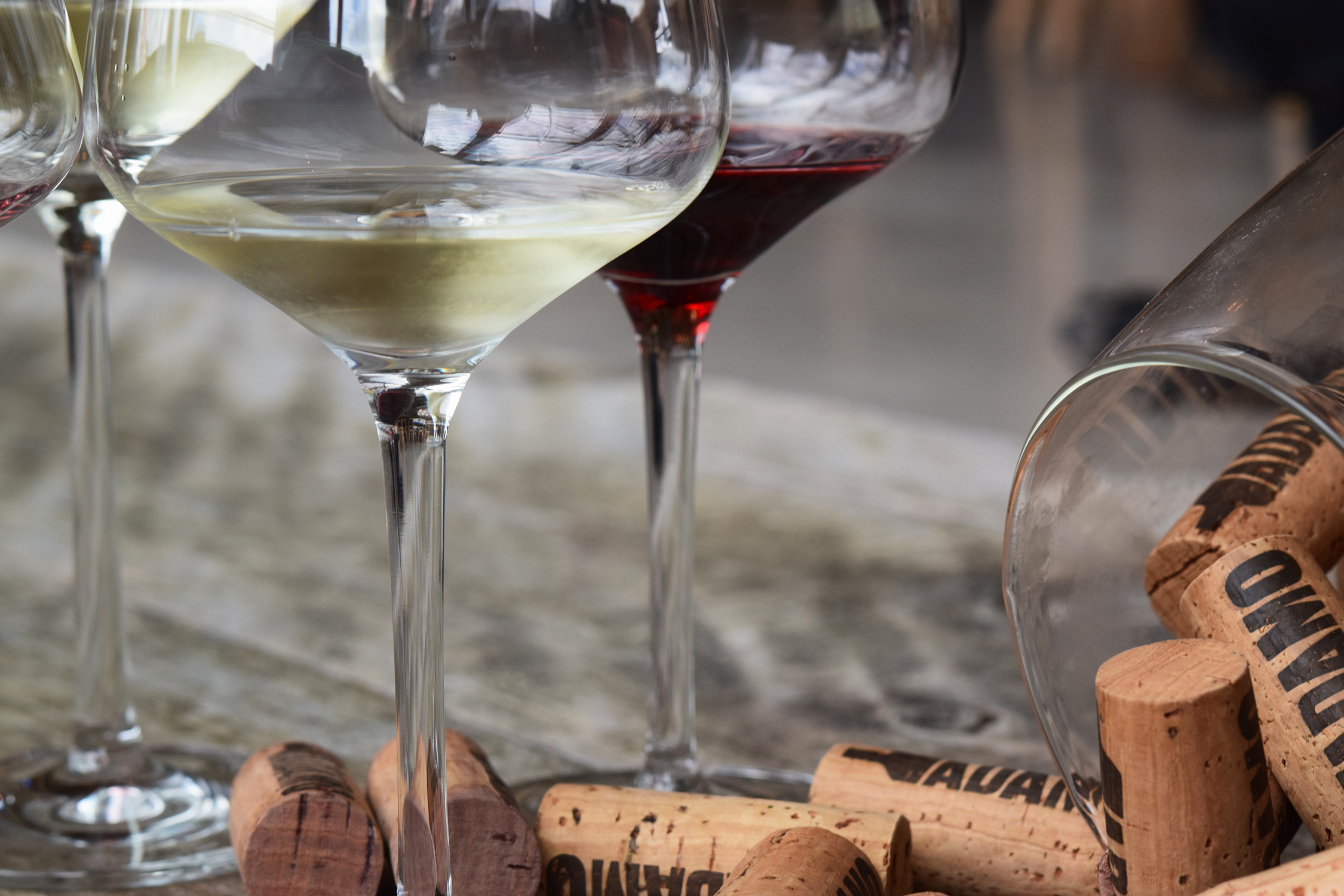 red and white wine in glasses with spilled corks